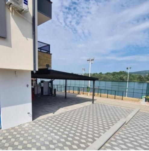 a building with a roof with a view of the water at Prenoćište SILVER LUX Srebrno Jezero 10 in Veliko Gradište