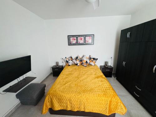 a bedroom with a bed with a yellow blanket at Spacious apartment 100m from the beach and promenade in Torrevieja