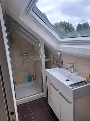 a bathroom with a sink and a shower with a skylight at maison 3 chambres 24h le mans in Le Mans