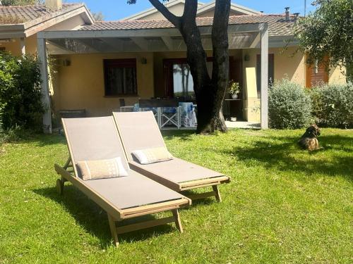 two chairs sitting in the grass in a yard at Cala dei Pirati in Punta Ala