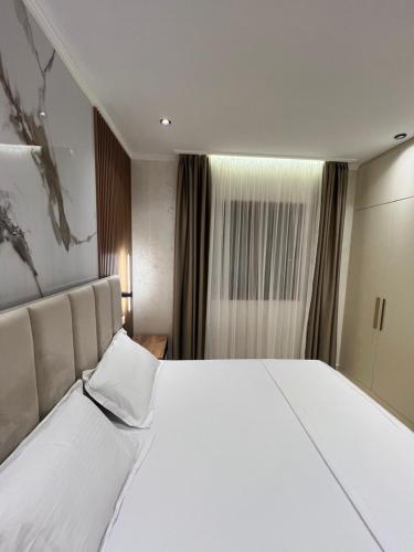 a large white bed in a hotel room at Kamberi Hotel & Apartments in Velipojë