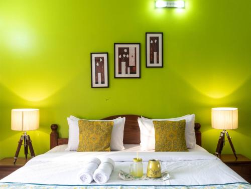 a green bedroom with a bed with a green wall at Thor Villa, 5BHK-Private Pool-Cook-Caretaker in Assagao