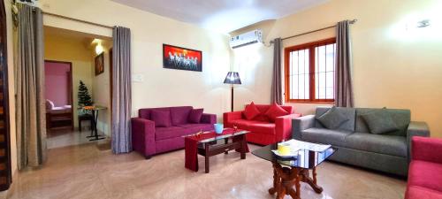 a living room with two couches and a table at Thor Villa, 5BHK-Private Pool-Cook-Caretaker in Assagao