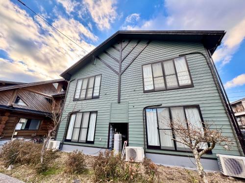 a gray house with white windows on top of it at 貸別荘はこぶね -Vacation rental Hakobune- in Yufu