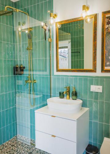 a bathroom with a sink and a shower with a mirror at Kołłątaja 23 Apartments in Wrocław