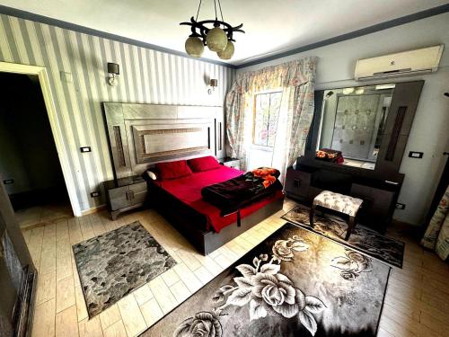 a living room with a red couch and a mirror at شقة غرفتين نوم بحديقة خاصة في المعمورة الشاطئ دور أرضي in Alexandria