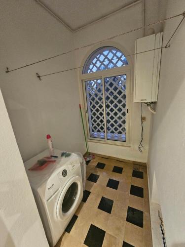 a washing machine in a room with a window at Marina Hammamet South in Yasmine