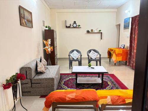 a living room with a couch and a table and chairs at Homely Hideout in Pālampur