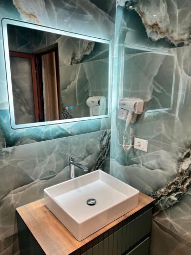 a bathroom with a sink and a mirror at Kamberi Hotel & Apartments in Velipojë