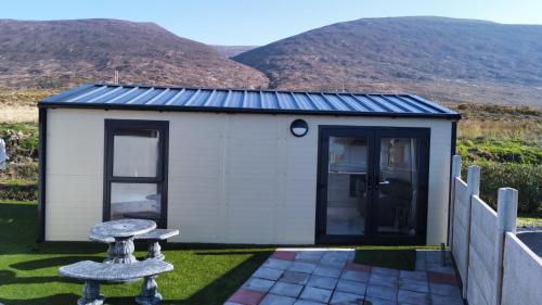 a small white building with mountains in the background at Atlantic Sea View in Tralee