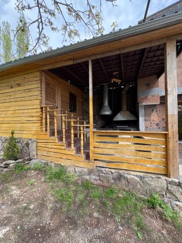a wooden house with a porch with two bells at Old Byurakan Cottage in Byurakan