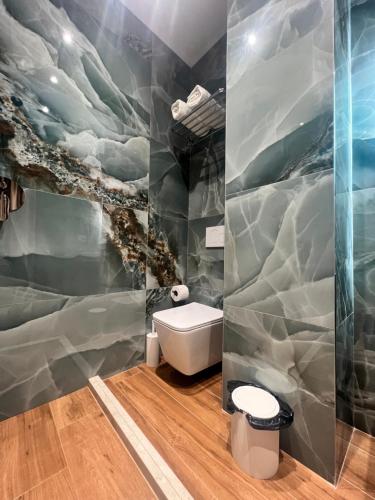a bathroom with a wave mural on the wall at Kamberi Hotel & Apartments in Velipojë