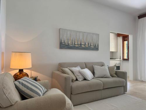 a couch and a chair in a living room at Cala dei Pirati in Punta Ala