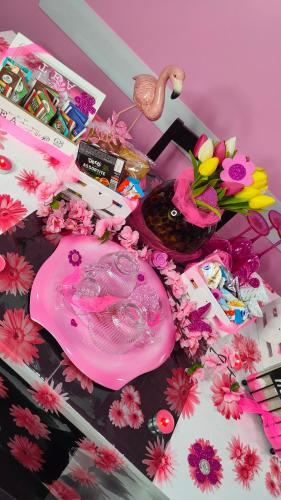a table with a pink plate and flowers on it at Secret Room Anagni in Anagni