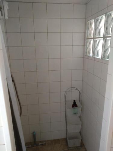 a tiled shower with a shelf and a window at Humlesten's Gård in Huaröd