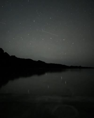 a night view of a lake with a starry sky at Taketomijima Guesthouse and je Taime in Taketomi