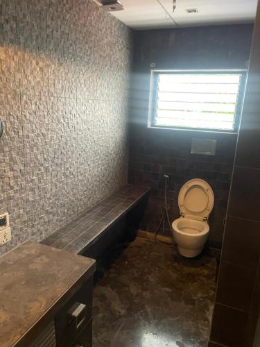 een badkamer met toilet, wastafel en raam bij Penthouse retreat by speed homes in Calcutta