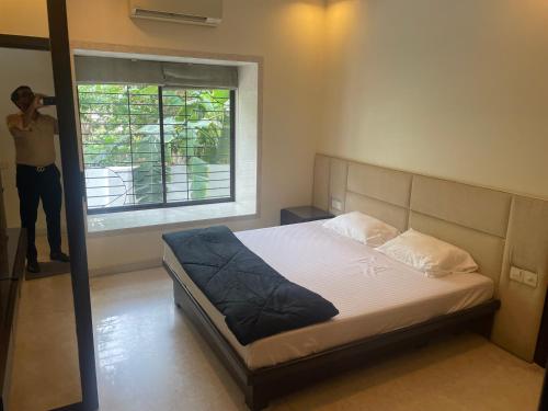 een man die een foto neemt van een bed in een slaapkamer bij Penthouse retreat by speed homes in Calcutta
