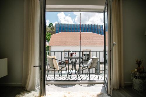 a room with a balcony with a table and chairs at Douro's Heart Stay in São João da Pesqueira