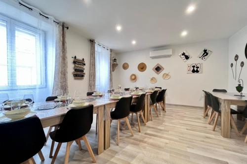une grande salle à manger avec une longue table et des chaises dans l'établissement La Grange de Lucien - Meyras, à Meyras