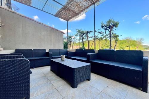 une terrasse avec des canapés bleus et une table dans l'établissement La Grange de Lucien - Meyras, à Meyras