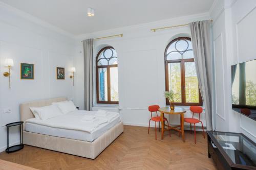 a bedroom with a bed and a table and chairs at Kołłątaja 23 Apartments in Wrocław