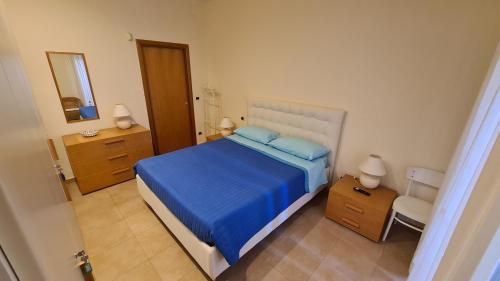a bedroom with a blue bed and a mirror at The Cozy Place in Bari Palese