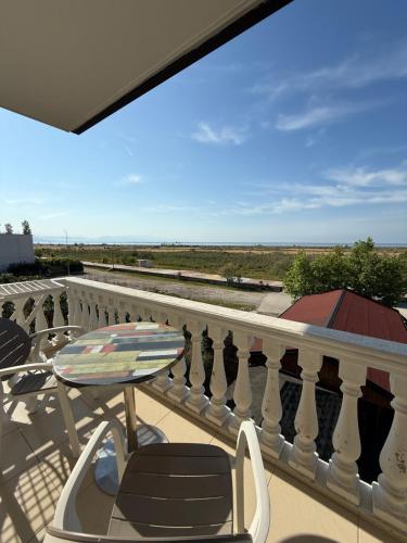 a balcony with a table and chairs and a view of the ocean at Kamberi Hotel & Apartments in Velipojë