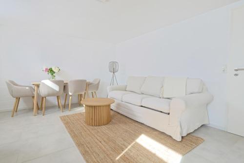 un salon avec un canapé blanc et une table dans l'établissement Souterrain in Timmendorfer Strand - Niendorf Ostsee, à Timmendorfer Strand