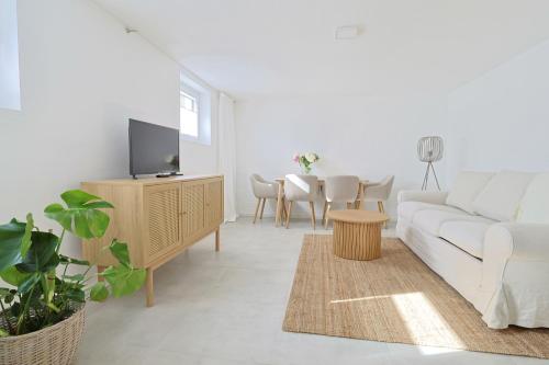 un salon avec un canapé blanc et une table dans l'établissement Souterrain in Timmendorfer Strand - Niendorf Ostsee, à Timmendorfer Strand