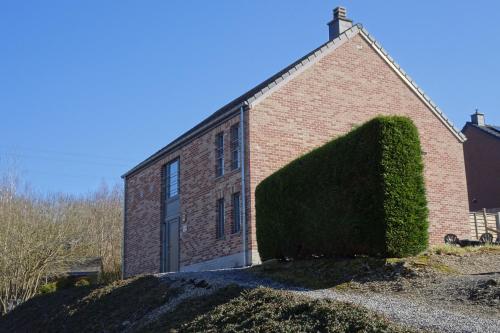 a brick building with a large bush in front of it at Au coin de détente in Durbuy