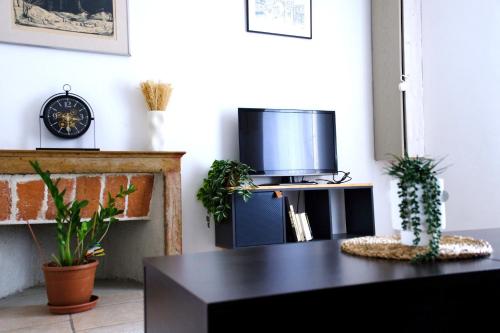 a living room with a tv and a table at Maison cosy et calme à 10min du centre in Dijon