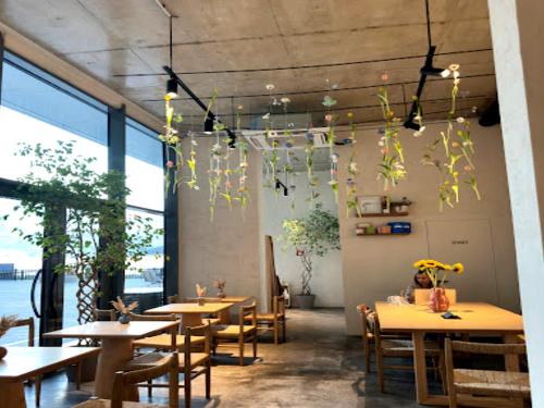 バトゥミにあるBatumi View Apartmentsのテーブルと椅子、花が飾られた天井のレストラン