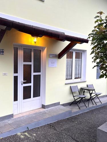 two chairs and a table outside of a house at Apartma Suzy in Bovec