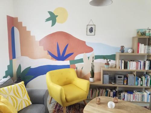 ベルジュラックにあるMaison spacieuse avec jardin clos au calmeのリビングルーム(ソファ、黄色の椅子付)