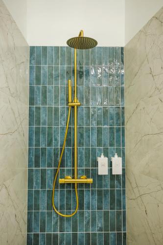 a shower in a bathroom with blue tiles at Kołłątaja 23 Apartments in Wrocław