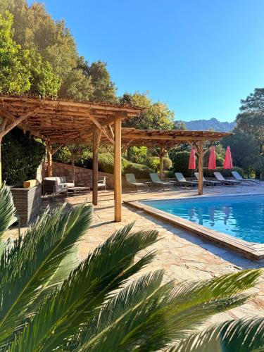 une piscine avec une pergola en bois et un complexe hôtelier dans l'établissement Villa à Conca avec piscine pour 8 personnes en Corse du Sud, à Conca