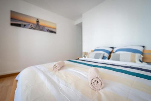 une chambre avec un lit avec des serviettes dessus dans l'établissement Logement Vacances La Rochelle, à Aytré