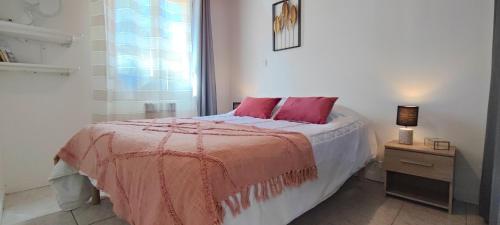 - une chambre avec un lit doté d'oreillers roses et d'une fenêtre dans l'établissement Gite d en Haut, à Sarlat-la-Canéda