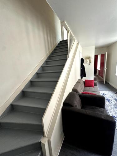 a living room with a staircase with a couch at T3 Hyper centre Place des Vosges in Épinal
