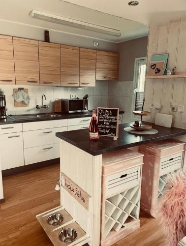a kitchen with a counter with a bottle of wine on it at Ferienhaus "Zauberwald" mit Pelletofen & Sauna in Meschede