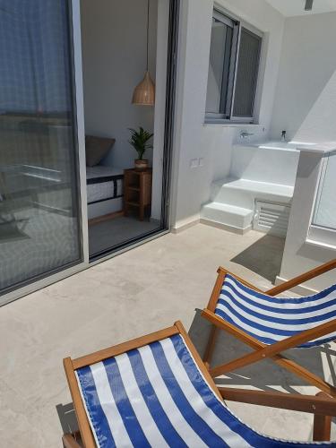a couple of chairs sitting on a patio at Blue Aura Beach villa Larnaca in Pervolia