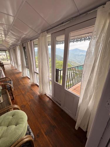 Habitación con balcón con vistas a las montañas. en Abode at Thanedar Estate, en Kanethi