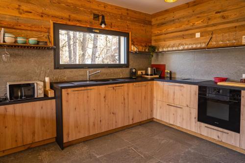 a kitchen with wooden cabinets and a window at Chalet du Trappeur in Les Orres