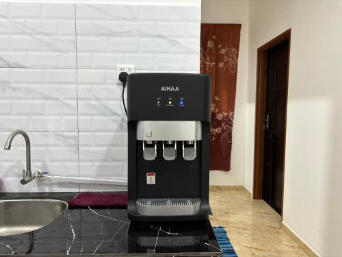 a coffee maker sitting on a counter in a kitchen at Pelangi Highway Homestay Biru,A5 in Sungai Mati