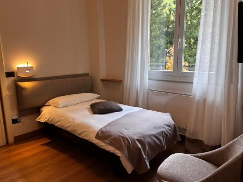 a small bed in a room with a window at Albergo San Carlo in Ormea