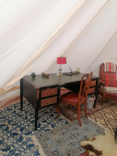 - un bureau mansardé avec une lampe et une chaise dans l'établissement NUIT DANS LA PORTE DES ETOILES glamping en luberon, à Robion