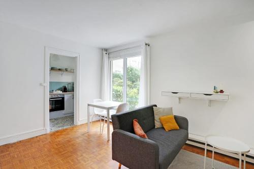 un salon avec un canapé et une table dans l'établissement Studio Dumas - Charonne by B'Your Home, à Paris
