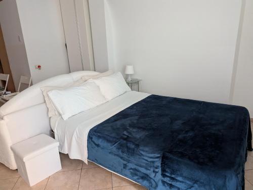 a white bed with a blue blanket on top of it at Appartamento Saragone in Salerno