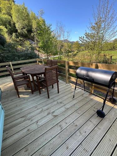 a bench and a table on a wooden deck at The Grosvner 61 in Dunoon